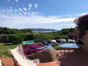A patio with outdoor furniture, a swimming pool, and a view of the landscape. - Villa 'Viola Con Piscina E Giardino' with Sea View, Private Pool and Wi-Fi (Punta Sardegna)
