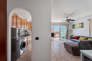 Een moderne keuken met roestvrijstalen apparatuur, een wasmachine en houten keukenkastjes.