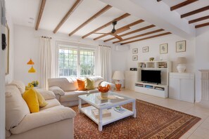 Ein Wohnzimmer mit einer Couch, einem Couchtisch, einem Fernseher und einem Kamin.