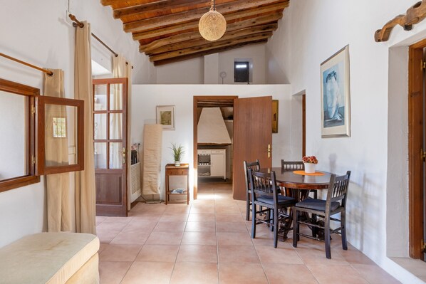 A dining area with a wooden table and chairs, a bench, and a ceiling fan.