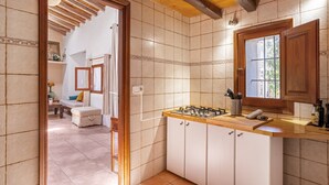 Une cuisine avec un plan de travail en bois, des armoires blanches et une fenêtre.