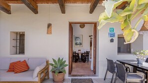 Une pièce comprenant un canapé, une plante en pot, un coin repas et une table avec des chaises.