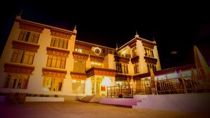A traditional building with multiple balconies and a well-lit entrance. - Gomang Boutique Hotel  (Leh)