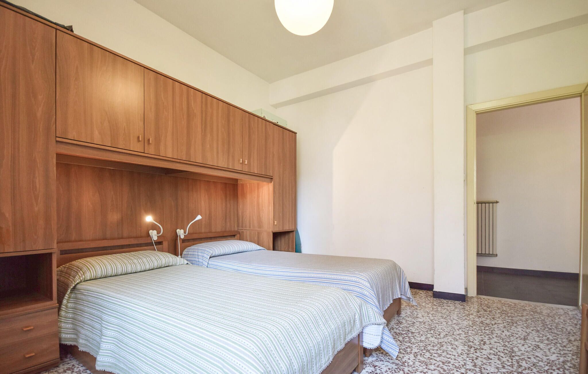 Ein Schlafzimmer mit einem Bett, einem Holzschrank und einer Heizung.