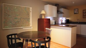 A compact kitchen with a dining area, a map on the wall, and a small island with a sink.