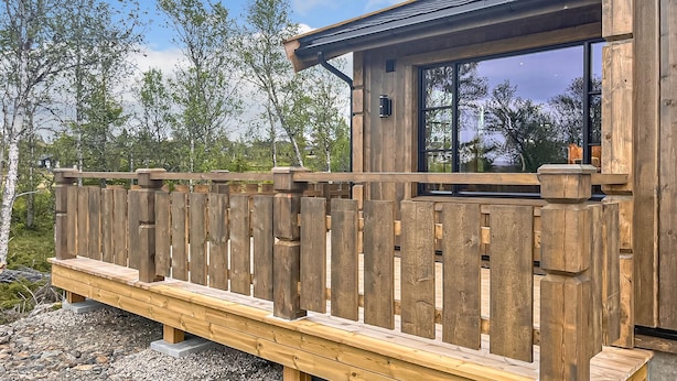 A wooden deck with a railing, a window, and a view of trees and sky. - 2 bedroom awesome home in Engerdal (Engerdal)