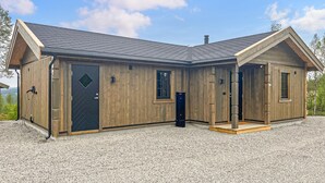 A wooden cabin with a sloped roof, a front door, and a small porch. - 2 bedroom awesome home in Engerdal (Engerdal)