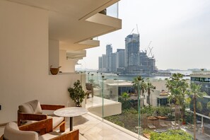 A modern balcony with a view of a city skyline and a body of water.