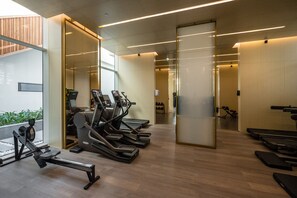 A gym with treadmills, stationary bikes, and rowing machines.