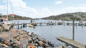 A rocky shoreline with a wooden dock extending into calm water. - Stunning home in Brännö (Brännö)
