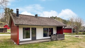 A single-story house with a tiled roof, a porch with a bench, and a small deck. - 2 bedroom stunning home in Degeberga (Degeberga)