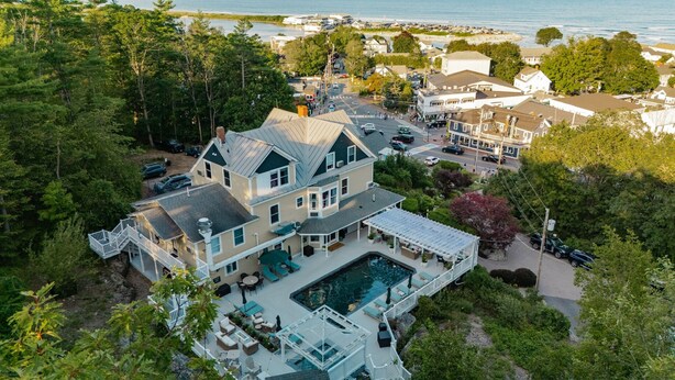 A large house with a swimming pool, surrounded by trees and a view of the sea. - The Trident Inn (Ogunquit)
