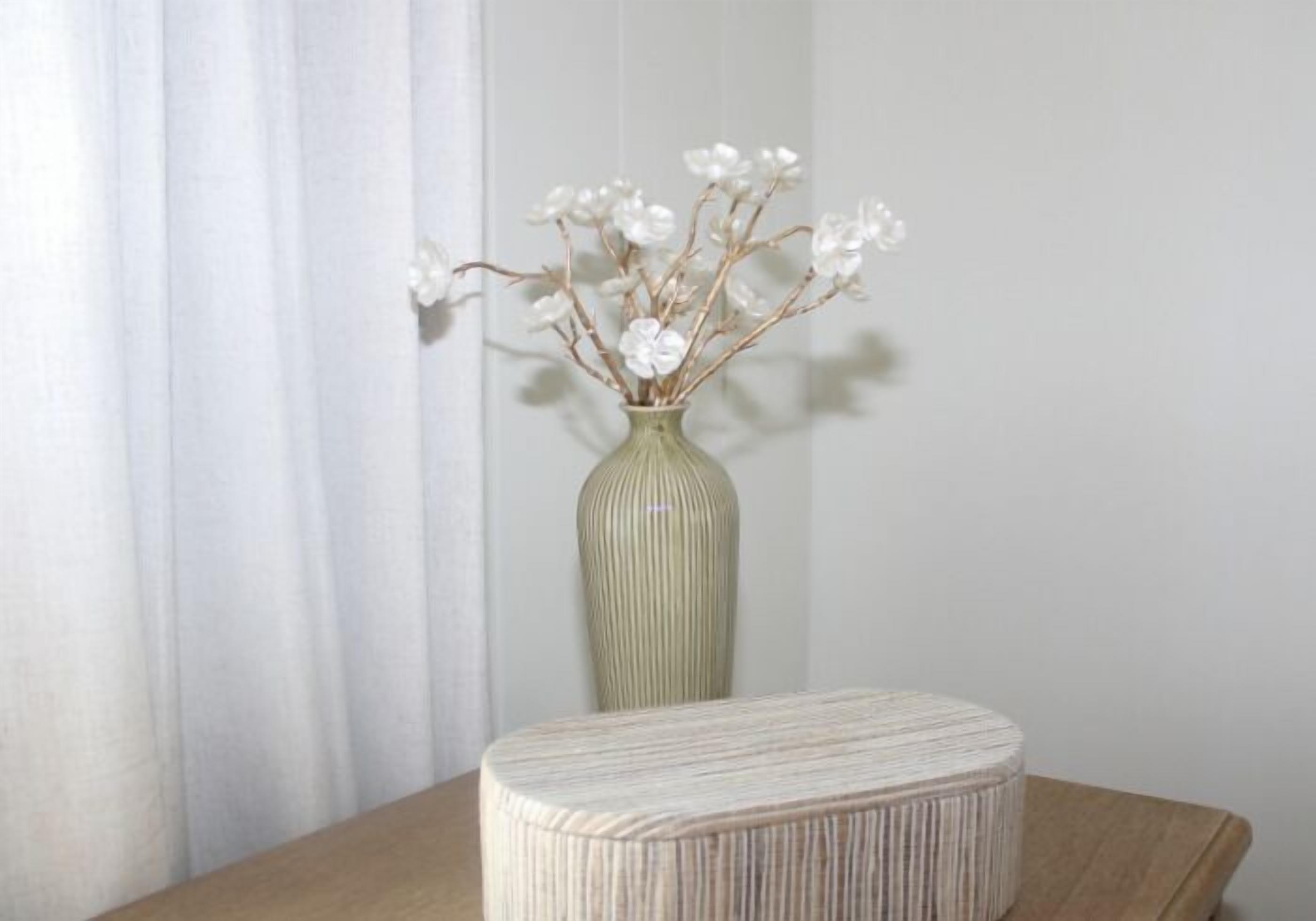 A vase with white flowers on a table.