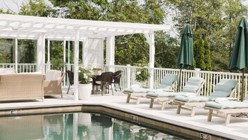 Una piscina al aire libre de temporada, sombrillas