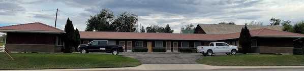 A motel with two parking spaces, a driveway, and a red-tiled roof. - The Padre Motel (Escalante)