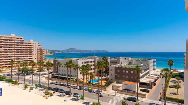 Une zone urbaine côtière avec de grands immeubles, une piscine et une vue dégagée sur la mer.