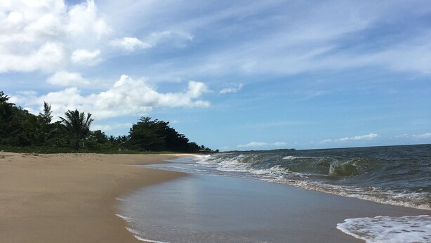 A beach with a sandy shore and gentle waves. - ESPAÇO RUSTIK  (Santa Cruz Cabrália)