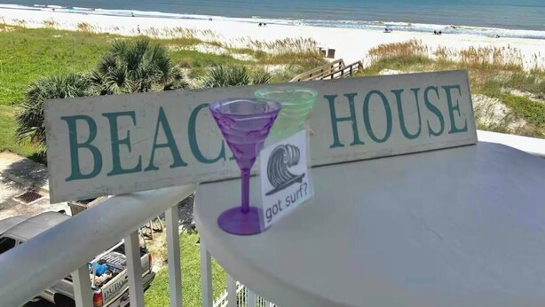 Schild eines Strandhauses mit Blick auf den Strand.