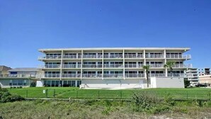 Ein mehrstöckiges Hotel mit flachem Dach und Balkonen an jeder Etage.