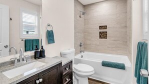 Un baño moderno con lavamanos, inodoro y bañera.
