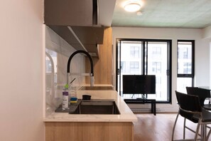 Een koelkast, een oven, een vaatwasser, kookgerei, borden en bestek