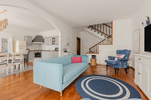 A living room with a sofa, a coffee table, and a dining area with chairs and a table.