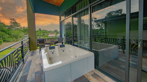 Et moderne udeområde med jacuzzi, træloft, skydedøre af glas og udsigt til haven.