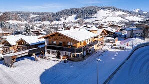 Un village enneigé aux bâtiments en bois, dont une maison remarquable appelée « Haus Daniela ».