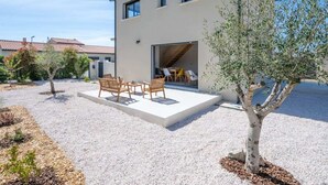 A modern two-story house with a patio area featuring outdoor furniture. - Maison Calypso de Narbonne (Narbonne)
