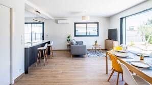 A modern living space with a kitchen, dining area, and seating area. - Maison Calypso de Narbonne (Narbonne)