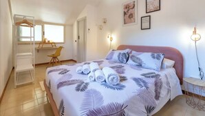 Un dormitorio con cama, escritorio y silla.