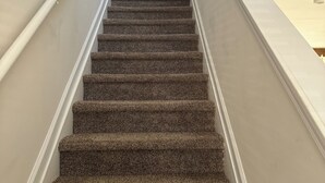 A carpeted staircase with white handrails and a white door at the top. - 3-bedroom Immaculate remodeled condo in marvelous Brentwood. (Brentwood)