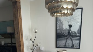 A dining area with a round table, leather chairs, a chandelier, and a framed picture on the wall. - 3-bedroom Immaculate remodeled condo in marvelous Brentwood. (Brentwood)