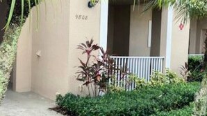 Una entrada de edificio con un camino de hormigón que lleva a una zona vallada.