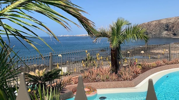A swimming pool with a view of the sea, surrounded by palm trees and a fence. - Bahia - 2 bedroom seafront (Palm-Mar)