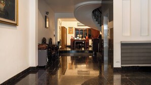 Ein geräumiger Flur mit poliertem Boden, ein Essbereich mit Tisch und Stühlen sowie eine Treppe, die in ein Obergeschoss führt.
