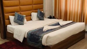 Un lit bien fait, avec une tête de lit, un tapis rouge et un plancher en bois.