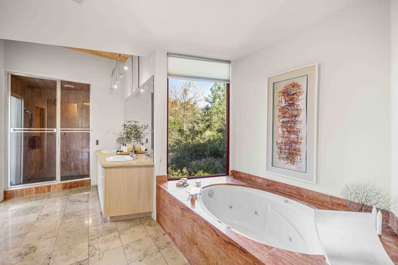 Ein modernes Badezimmer mit einer großen Badewanne, einer Duschkabine und Blick ins Freie.