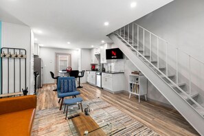 Een modern appartement met een woonkamer, keuken en een trap.