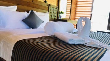 Una cama bien hecha con una colcha a rayas y un cabecero con diseño circular.