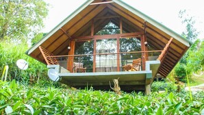 A wooden cabin with a balcony, surrounded by lush greenery. - Ella Crest by Aloft (Ella)