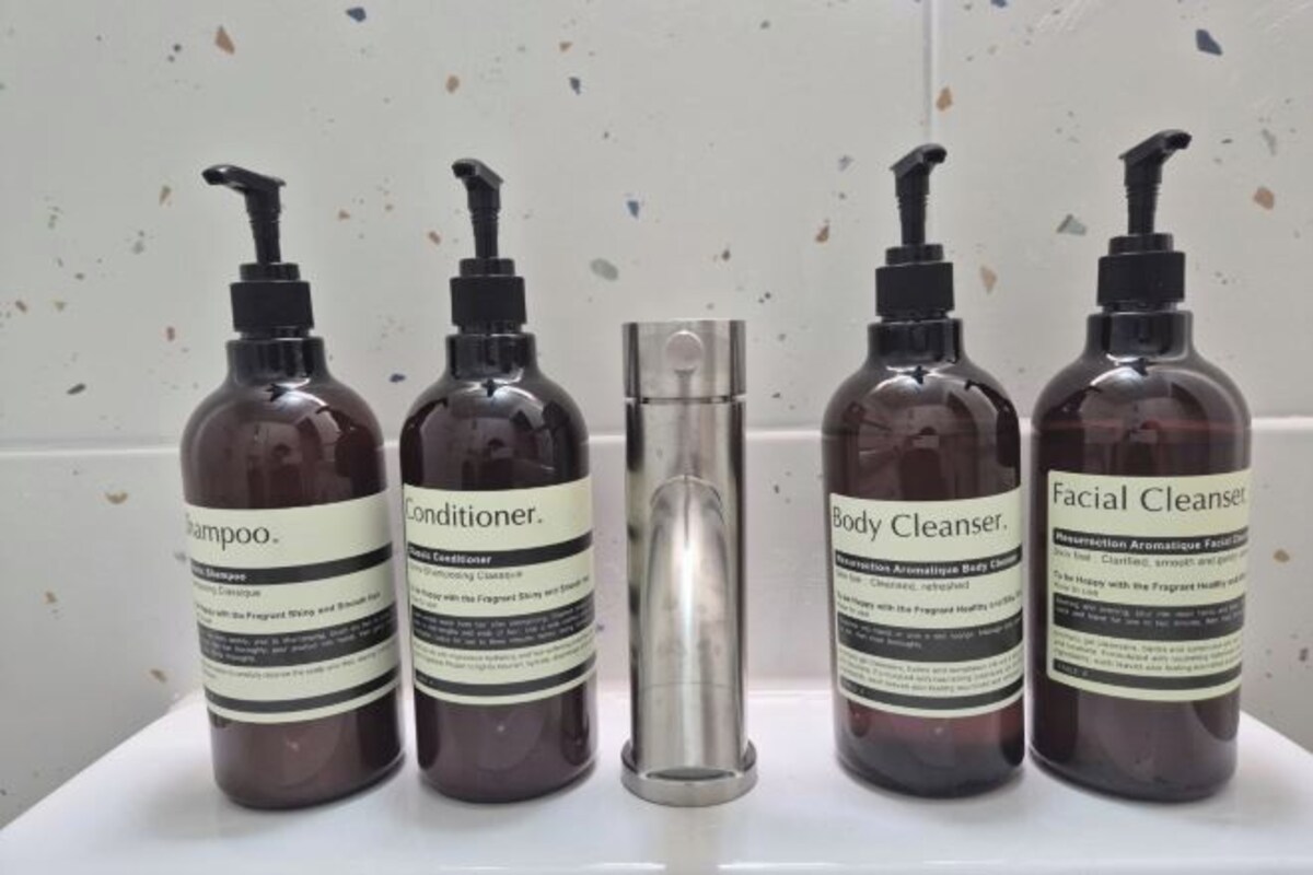 Four bottles of body care products on a white surface.
