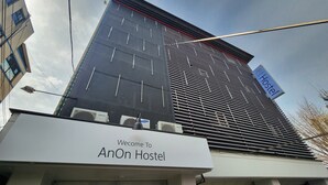 L’extérieur de l’auberge AnOn présente un design moderne, avec une enseigne bien visible et des unités de climatisation.