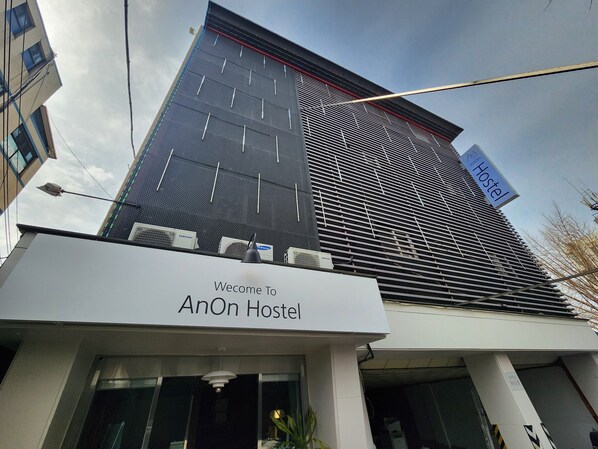 The exterior of AnOn Hostel with a modern design, featuring a prominent signboard and air conditioning units. - AnOn hostel (Seoul)