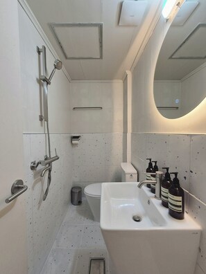 A modern bathroom with a shower, toilet, and sink. - AnOn hostel (Seoul)