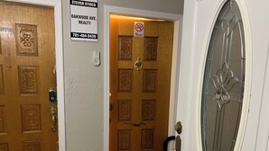 A door with a no smoking sign, a keypad lock, and a sign for Steven Stico Realty. - Charming 2-bedroom condo in delightful Chelsea with WiFi, AC (Chelsea)