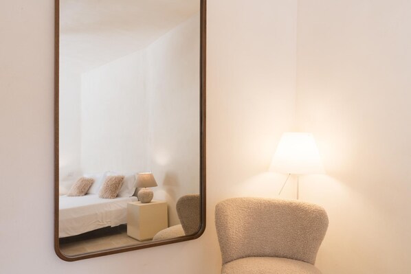 Une chambre à coucher avec un lit, une table de chevet, une lampe et une chaise.