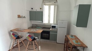 A compact kitchen with a dining area, featuring a microwave, oven, and a small window. - Nardò historical center (Nardò)