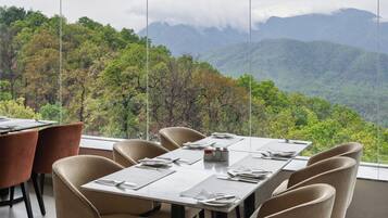 Un comedor con una mesa dispuesta para seis personas, con vistas a un paisaje montañoso.