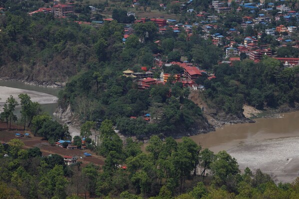 Un pueblo costero con edificios en una colina que domina un río.